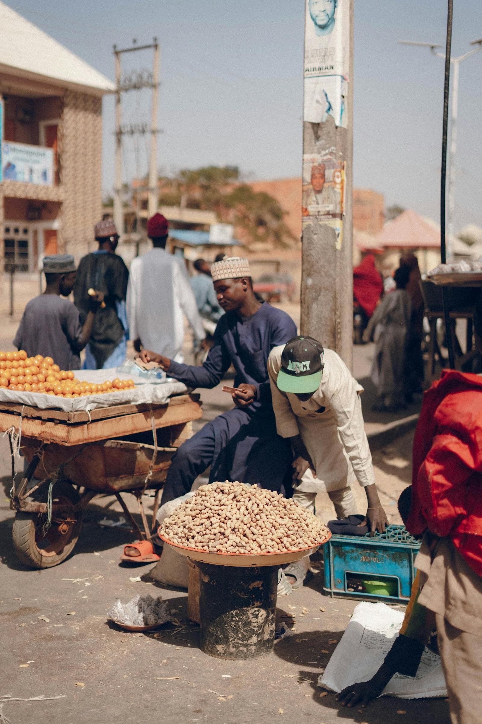 Vendors trading fresh goods at a busy open-air street market.